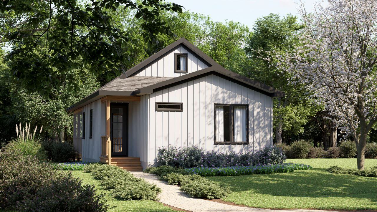 Cozy one-story starter home with loft featuring white board-and-batten siding, charcoal gable roof, covered front porch with wood steps, black-framed windows, brick paver walkway, and mature landscaping with flowering trees