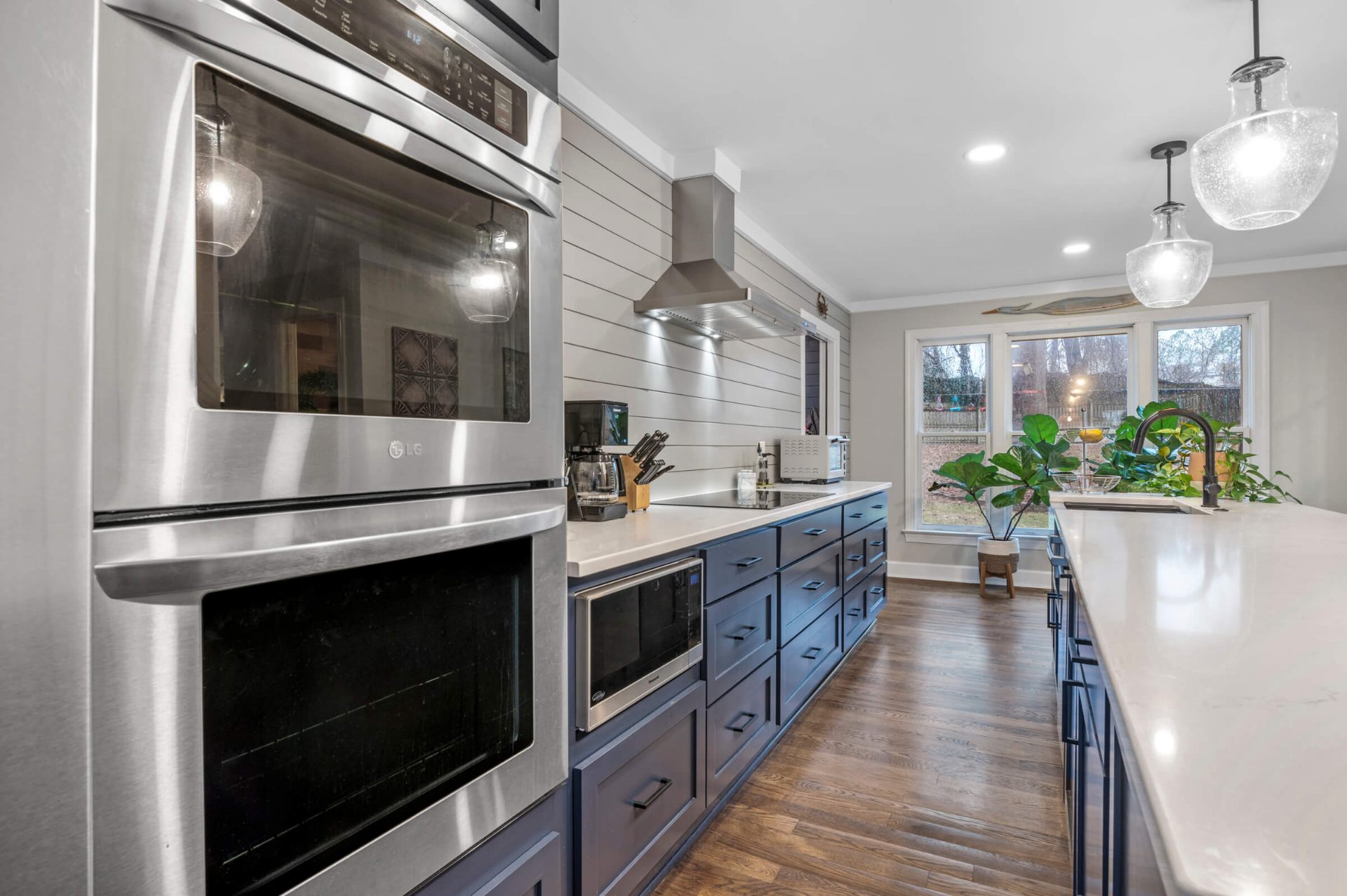Apex NC kitchen remodel featuring navy blue cabinets with LG stainless steel double wall oven and shiplap backsplash