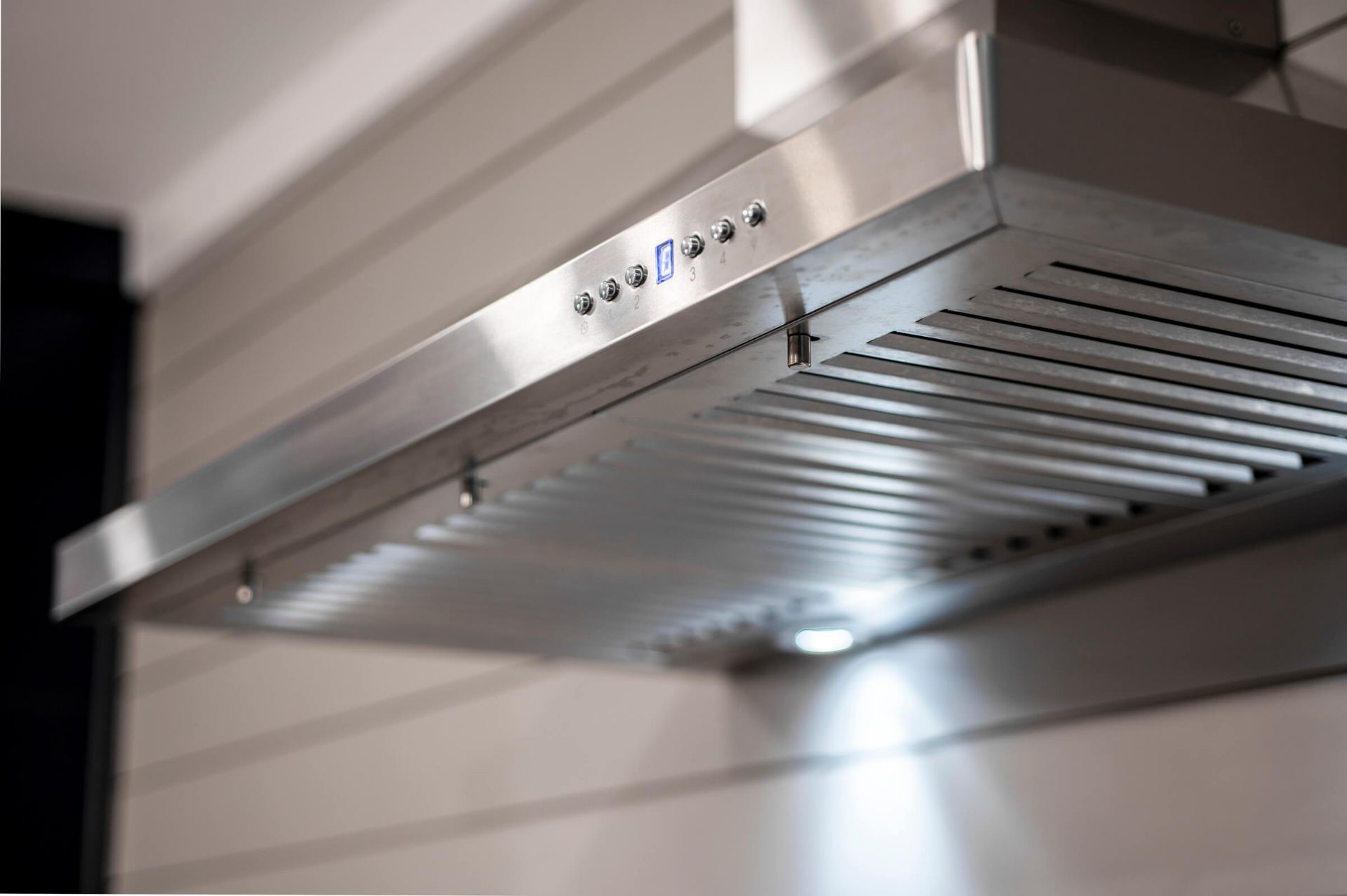 Professional-grade stainless steel range hood with LED lighting and push-button controls