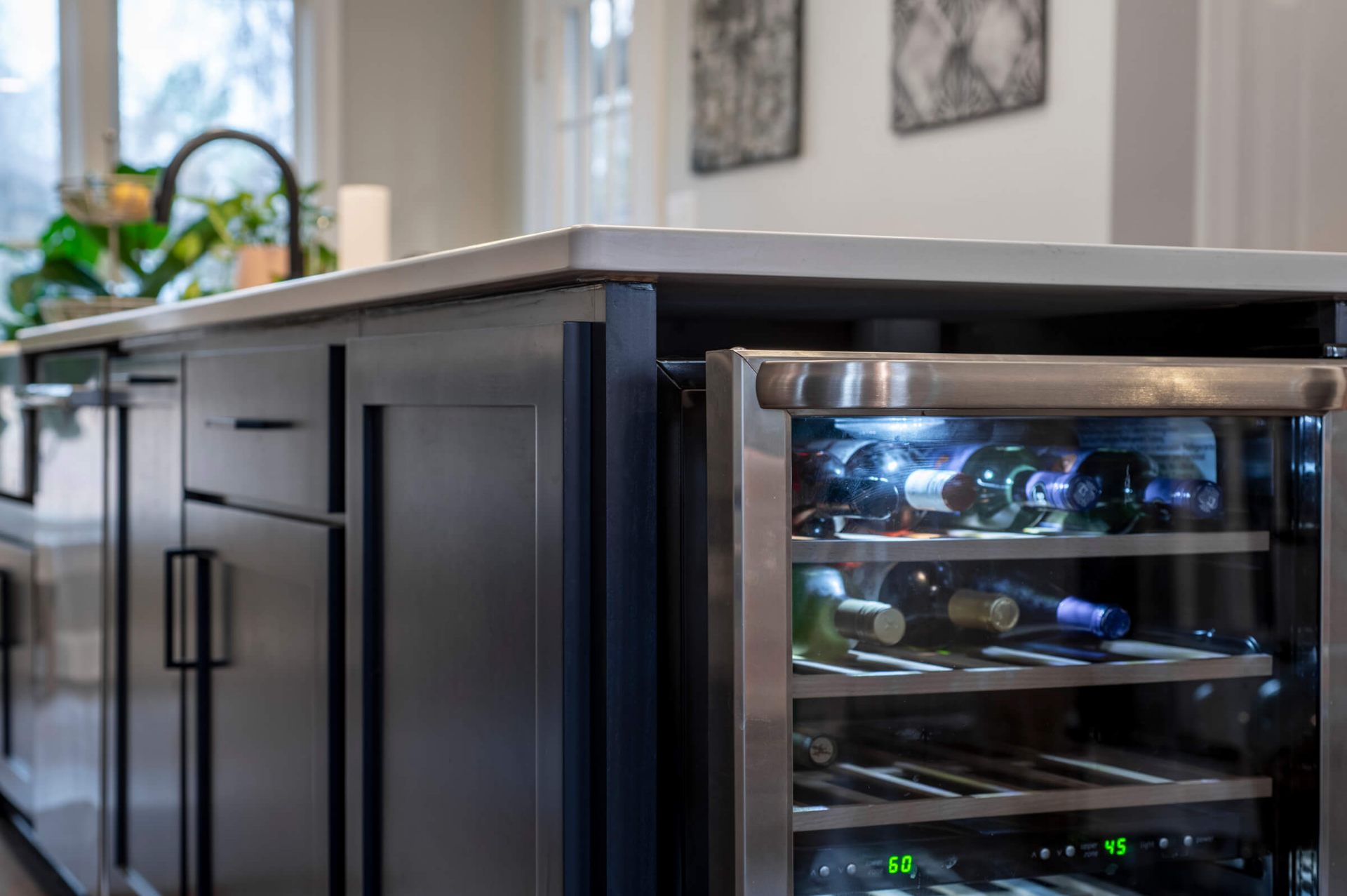 Custom kitchen island with integrated stainless steel wine refrigerator and navy blue cabinetry
