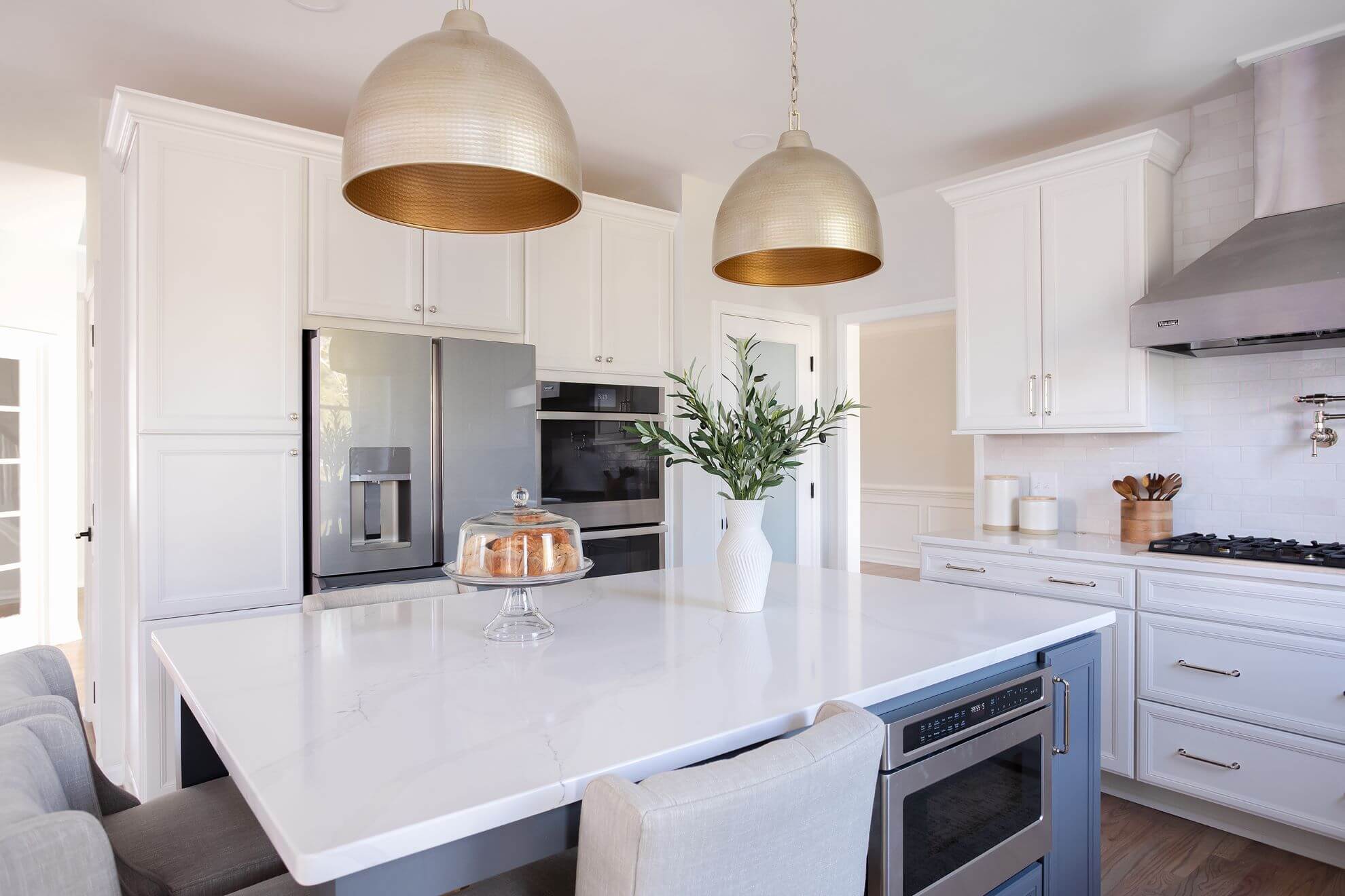 Cary NC kitchen remodel with white cabinets, gold hammered pendant lights, and blue kitchen island