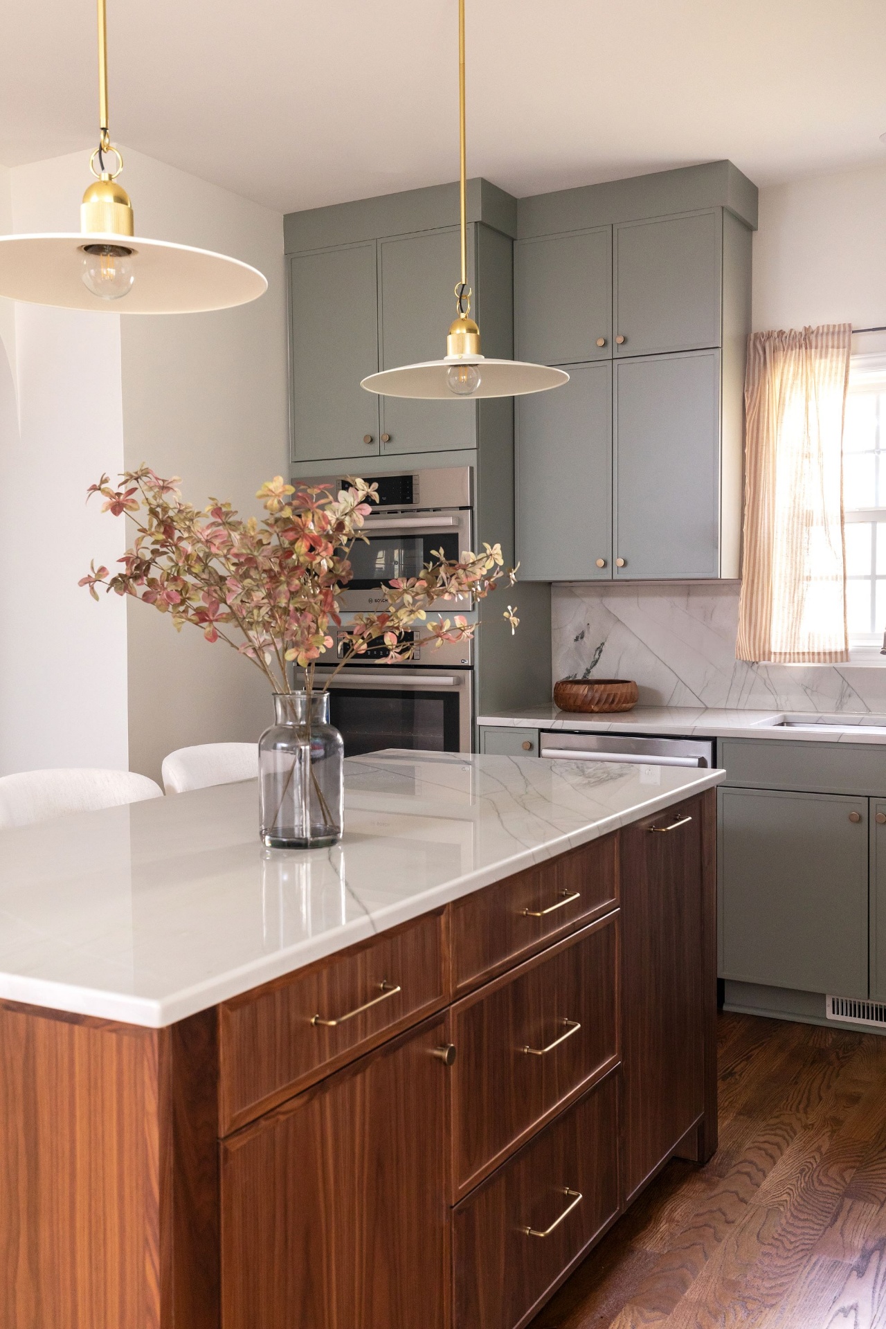 Elegant Cary kitchen featuring walnut island with marble top, sage green cabinetry, Bosch wall oven, and gold hardware