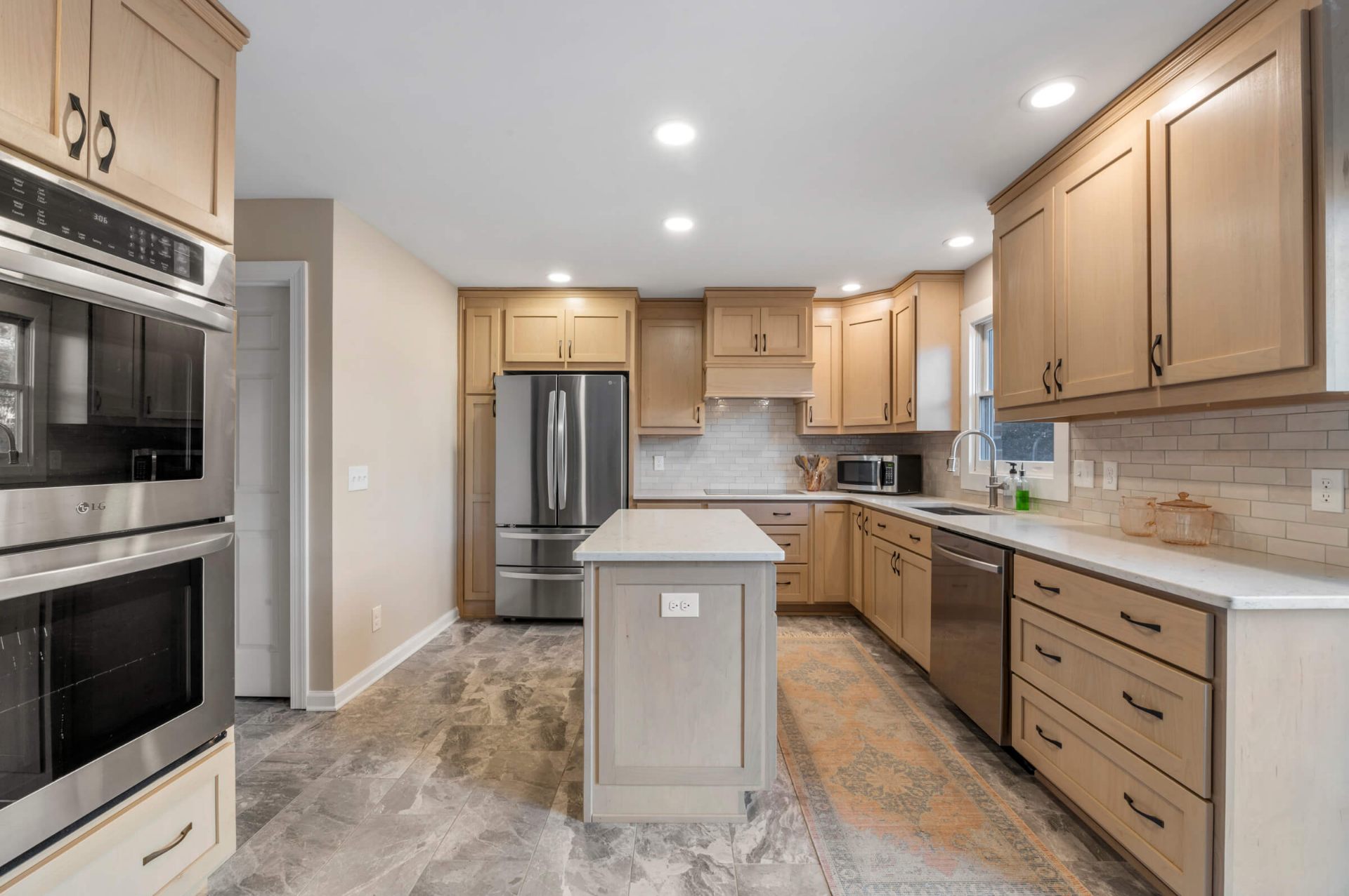 Full view Fuquay-Varina kitchen renovation featuring maple cabinets, center island, subway tile backsplash, and gray tile floors