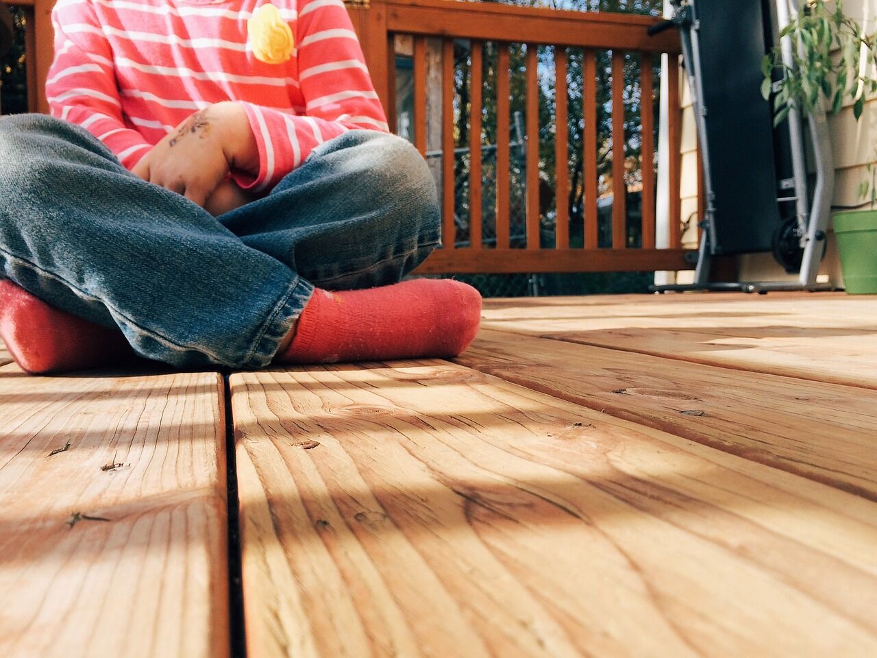 beautiful wood grain deck with boy sitting on surface