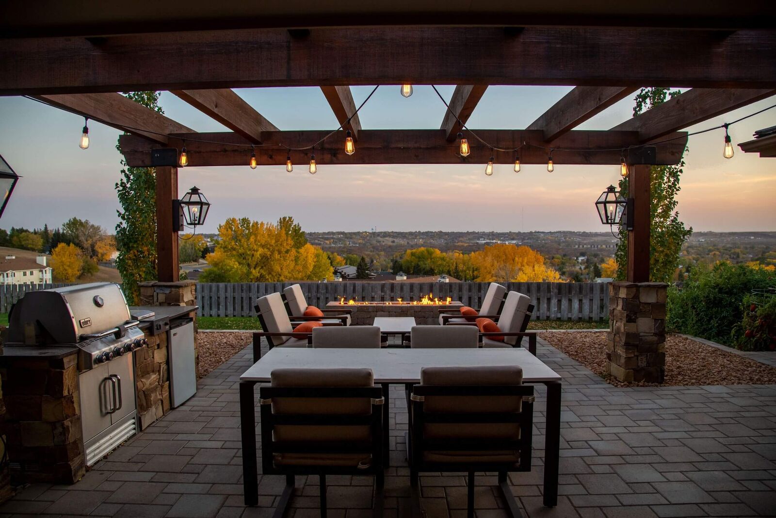 outdoor living space at sunset with pergola and firepit