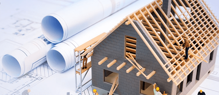 preconstruction guide with blueprint and house under construction