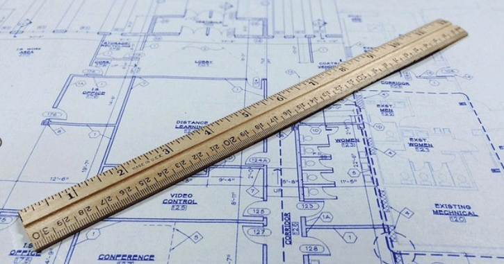 a ruler and blueprint describing what is preconstruction